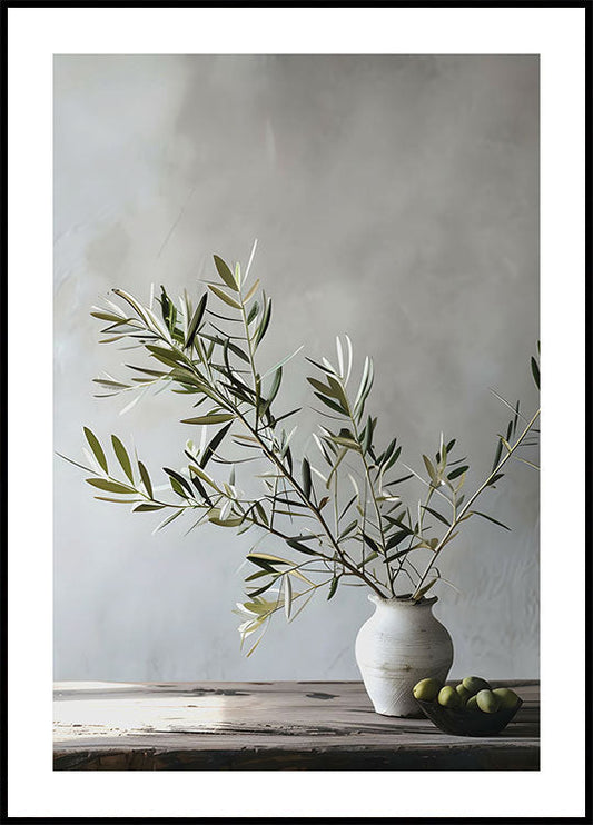 a white vase filled with green olives on top of a wooden table