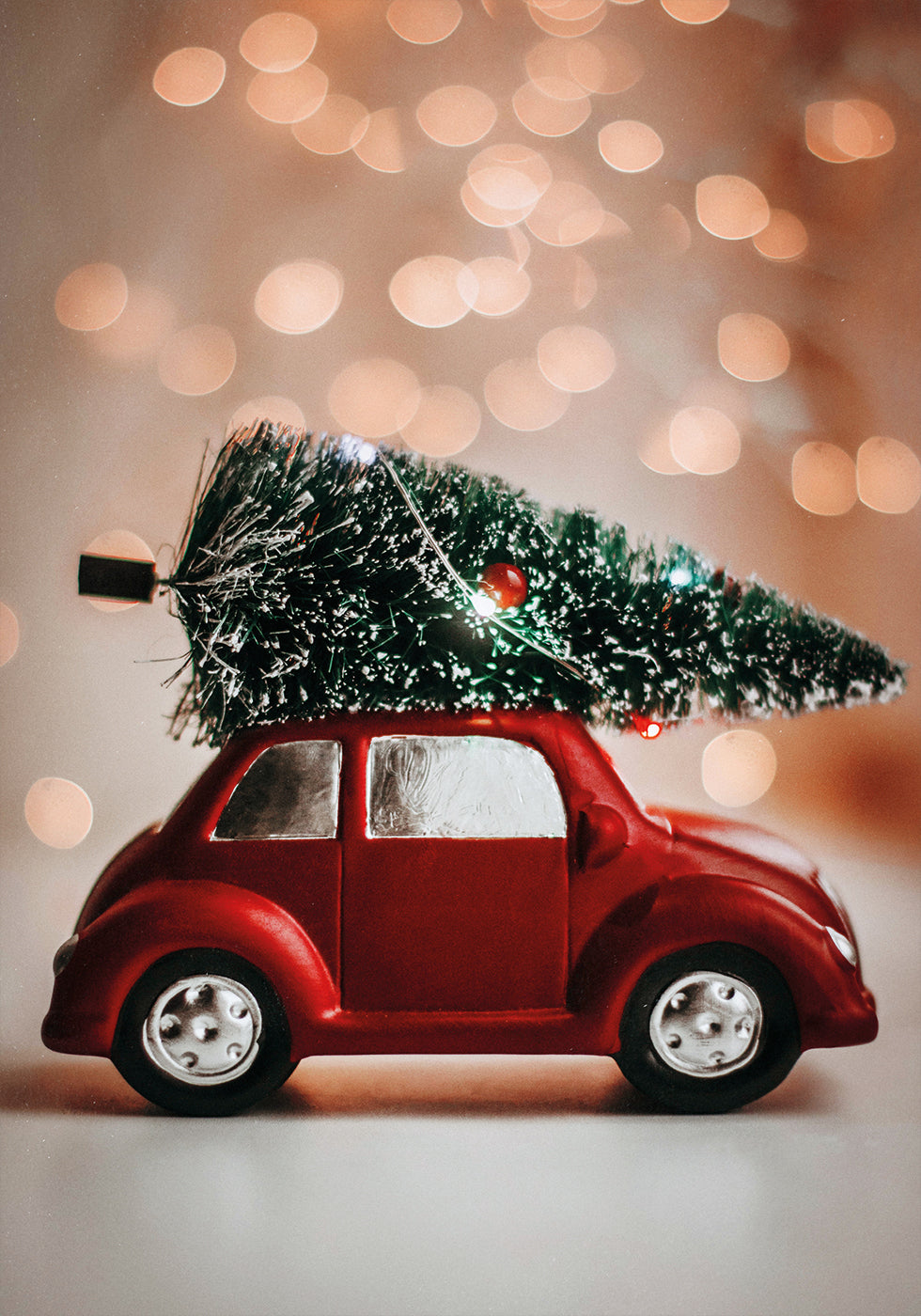 a red toy car with a christmas tree on top of it